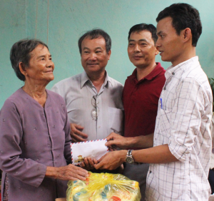 Anh Lê Trương Đại, đại diện Shoppystar và các nhà hảo tâm trao 3,1 triệu đồng, phần quà cho bà Biện Thị Thanh - Ảnh: KIM LIÊN